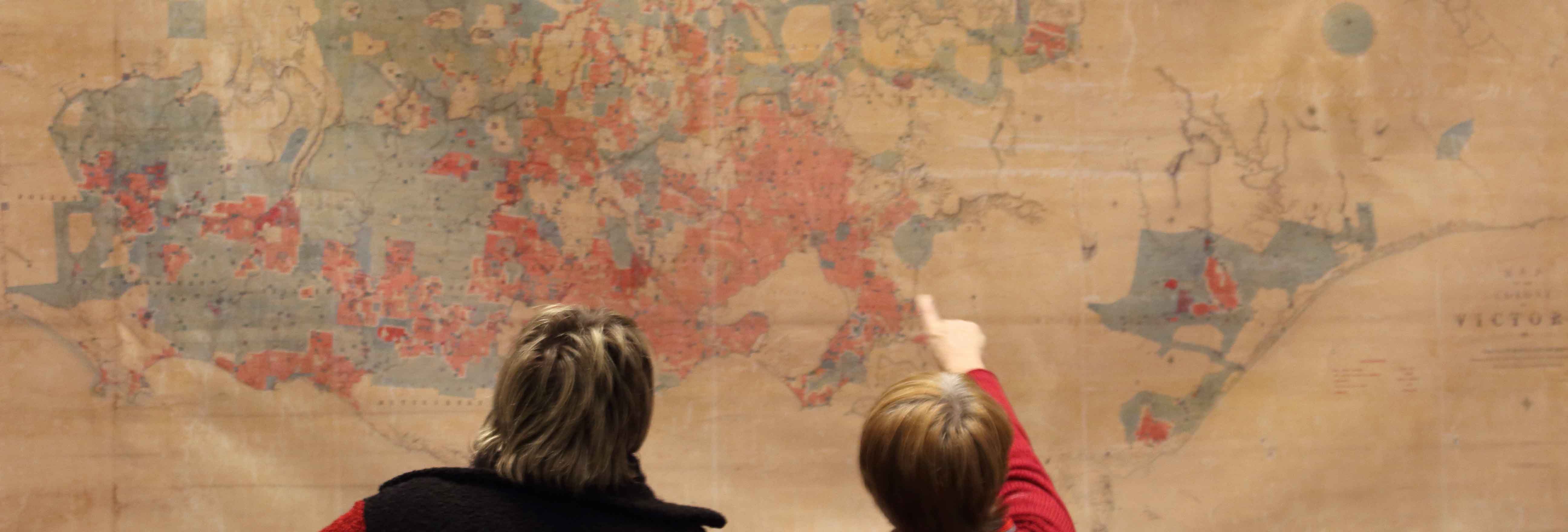 People looking at a wall-hanging map